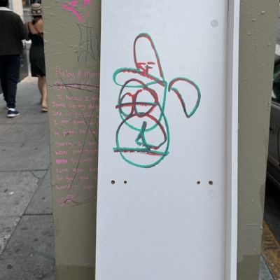 A utility box covered in graffiti, with a red and green scribble drawn on a white panel