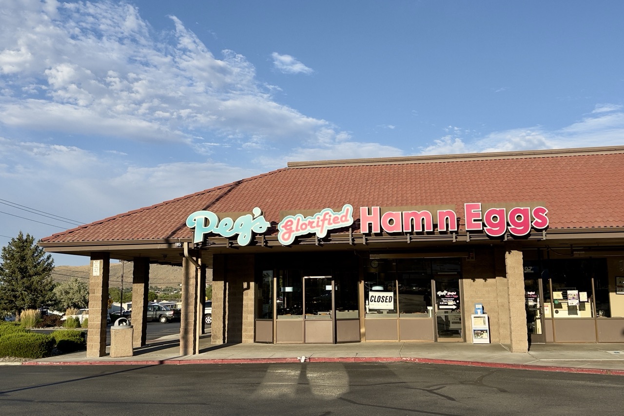 The storefront of Peg's Glorified Ham n Eggs diner, closed, under a red tile roof