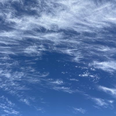 Wispy cirrus clouds streaking across a blue sky