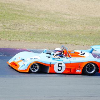A powder-blue and orange Gulf Mirage prototype, number 5, cornering.